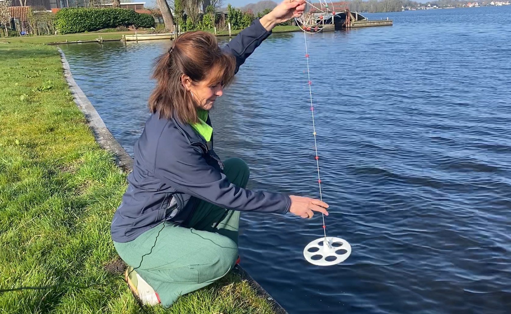 Vrouw doet een watermetingmeting in een meer.