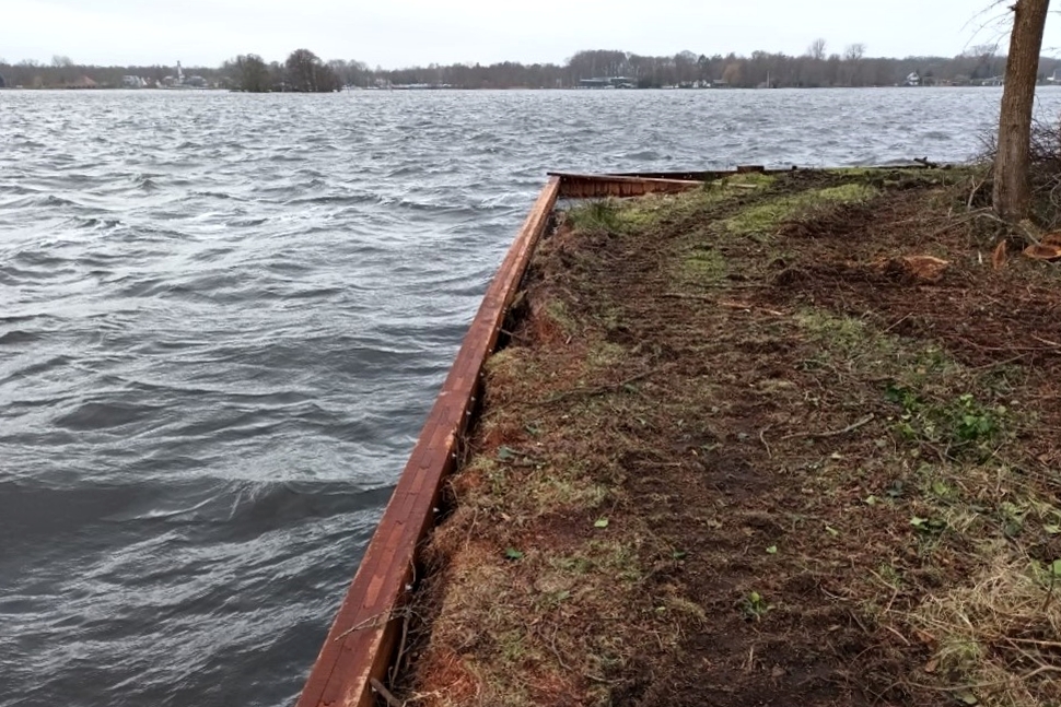 Houten beschoeiing tussen water en een eiland