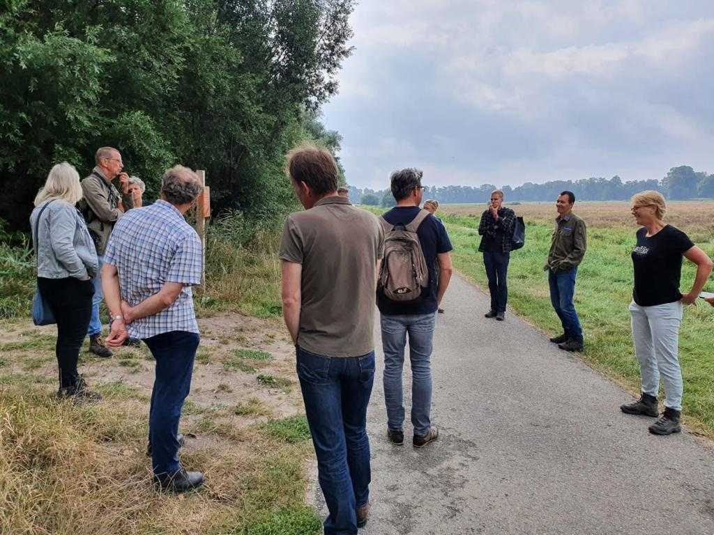 Groep mensen luisterend op een landweg