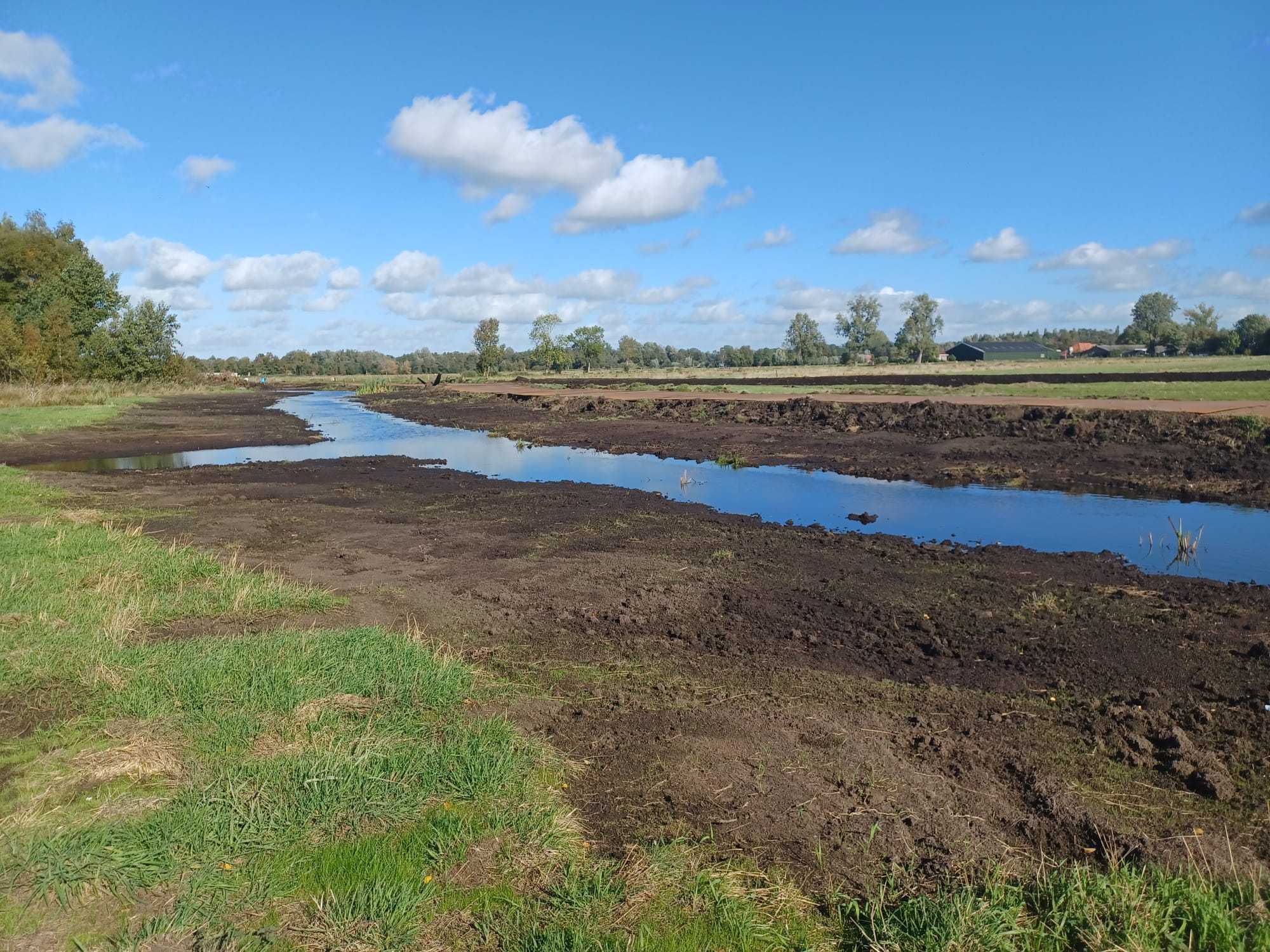 Een dunne strook water tussen stroken aarde en gras