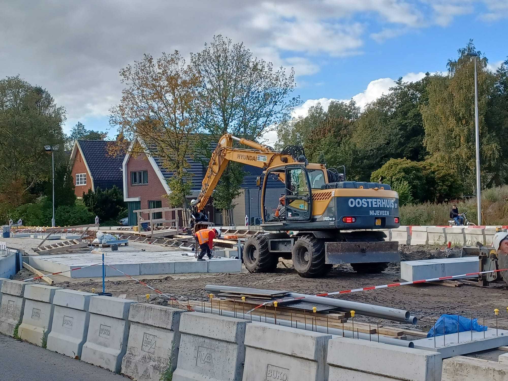 Bouwplaats met huizen en bomen op de achtergrond