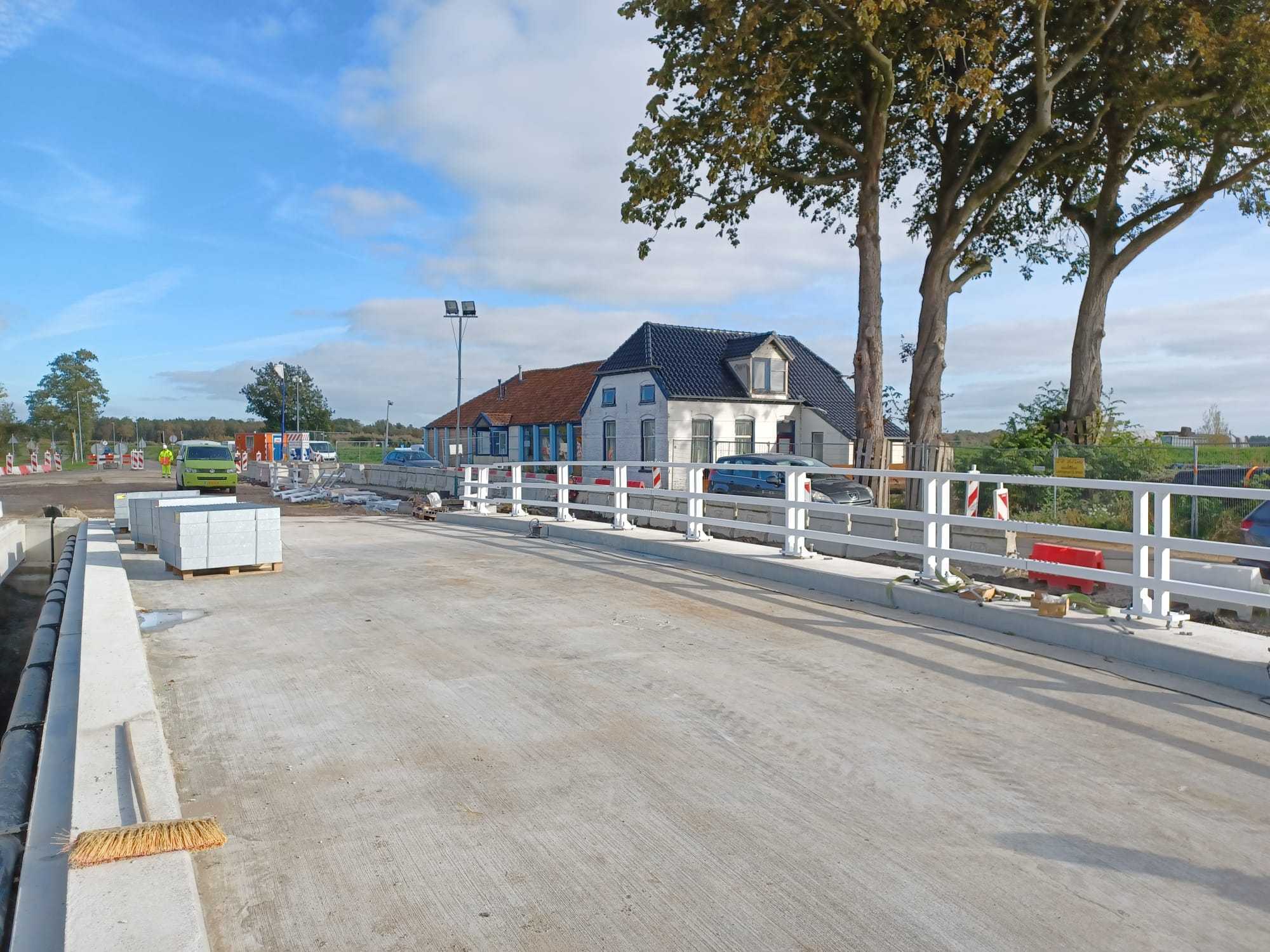 Aanleg van een nieuwe brug met net geplaatste witte leuningen