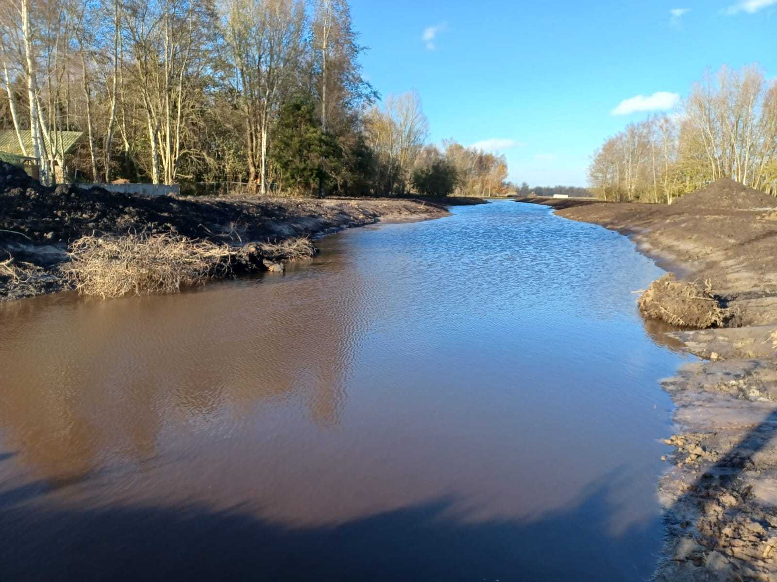 Een slenk met bomen op de achtergrond en een blauwe lucht