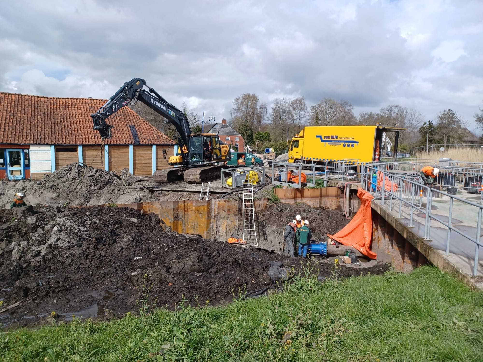 Bouwplaats met een werkvoertuig, vrachtwagen en werklui